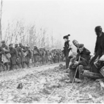 French refugees watch the regiment march through the Bois de Boliers near Sedan 9 November 1918 - the day after the death of Private Patterson.